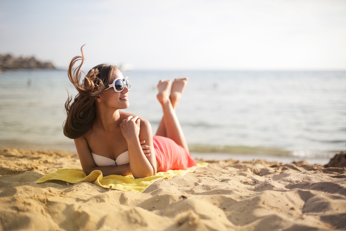 Woman on the beach with sunglasses - protecting your eyesight
